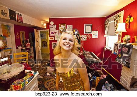 Stock Image - Teen girl dressing up in messy room. Fotosearch
