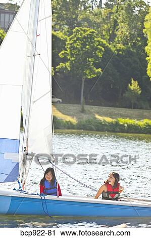 Two girls sailing small boat View Large Photo Image Stock Image - Two girls sailing small boat. Fotosearch