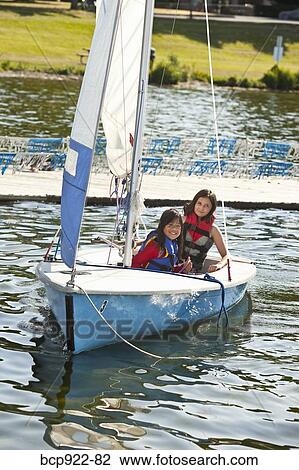 Stock Image - Two girls sailing small boat. Fotosearch