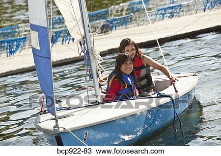 Two girls sailing small boat View Large Photo Image Stock Image - Two girls sailing small boat. Fotosearch