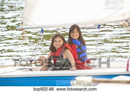 Two girls sailing small boat View Large Photo Image Stock Photograph - Two girls sailing small boat. Fotosearch