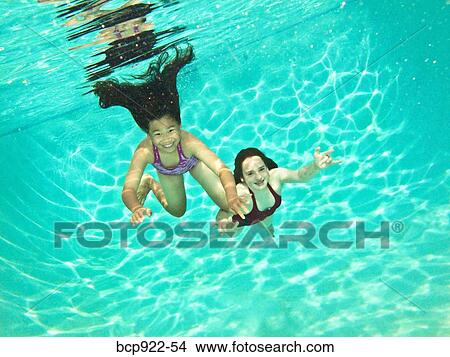 Two girls swimming under water View Large Photo Image Picture - Two girls swimming under water. Fotosearch
