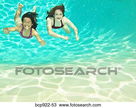 Two girls swimming under water View Large Photo Image Stock Image - Two girls swimming under water. Fotosearch