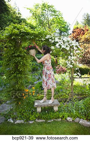 Woman in flowered dress in garden View Large Photo Image Stock Photo - Woman in flowered dress in garden. Fotosearch