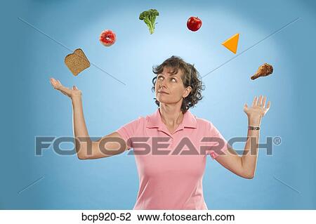 Stock Image - Woman juggling different foods. Fotosearch