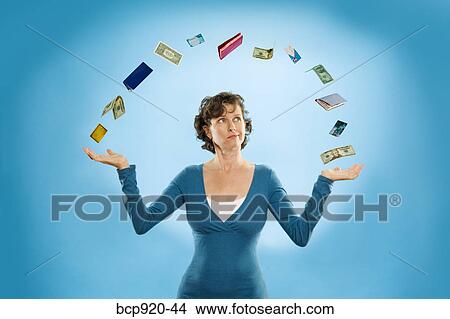 Picture - Woman juggling financial items. Fotosearch