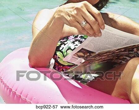Woman reading magazine in pool View Large Photo Image Stock Photo - Woman reading magazine in pool. Fotosearch