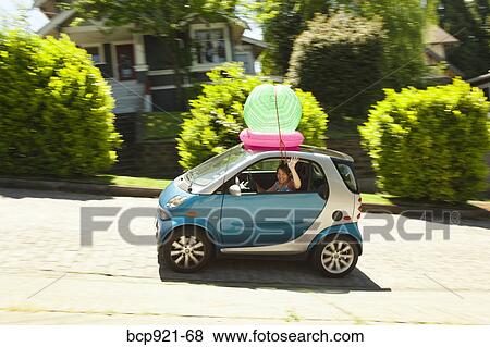 Woman with beach ball on smart car View Large Photo Image Stock Photo - Woman with beach ball on smart car. Fotosearch
