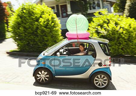 Woman with beach ball on smart car View Large Photo Image Stock Photo - Woman with beach ball on smart car. Fotosearch