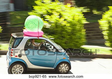 Woman with beach ball on smart car View Large Photo Image Stock Photography - Woman with beach ball on smart car. Fotosearch