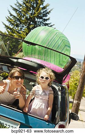 Stock Image - Woman with girl in back of smart car. Fotosearch