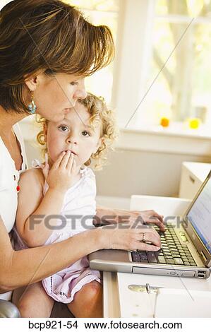 Woman with young child in home office View Large Photo Image Picture - Woman with young child in home office. Fotosearch