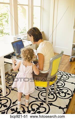 Woman with young child in home office View Large Photo Image Stock Image - Woman with young child in home office. Fotosearch