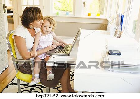 Woman with young child in home office View Large Photo Image Stock Image - Woman with young child in home office. Fotosearch