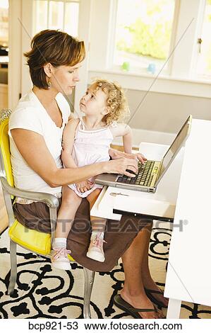 Woman with young child in home office View Large Photo Image Stock Image - Woman with young child in home office. Fotosearch