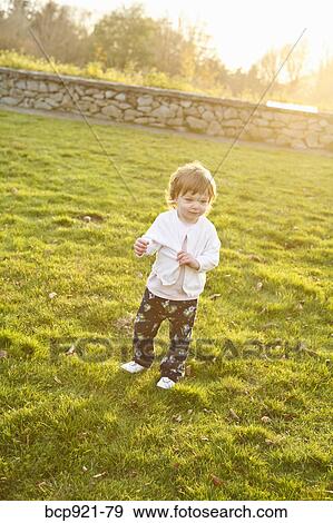 Young girl in field View Large Photo Image Stock Photo - Young girl in field. Fotosearch