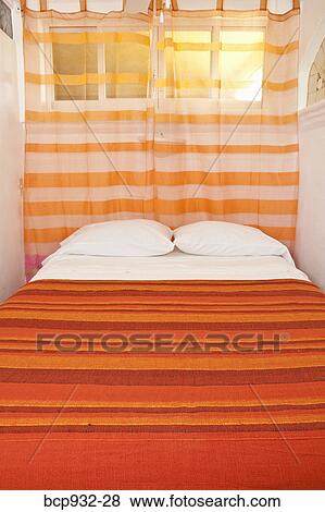 Stock Photo - bed with striped cover. Fotosearch