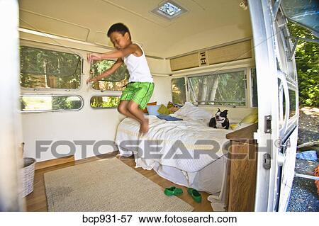 Boy and dog on bed in camper View Large Photo Image Stock Photo - Boy and dog on bed in camper. Fotosearch