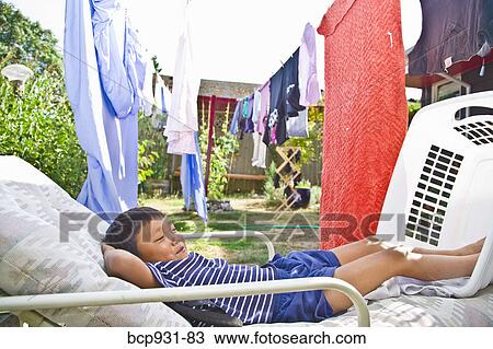 boy on chaise under clotheslines View Large Photo Image Stock Image - boy on chaise under clotheslines. Fotosearch