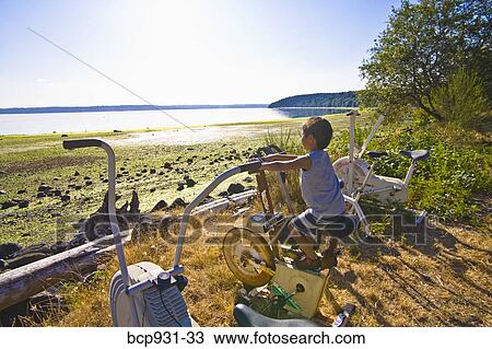 boy on exercise bike next to beach View Large Photo Image Stock Image - boy on exercise bike next to beach. Fotosearch