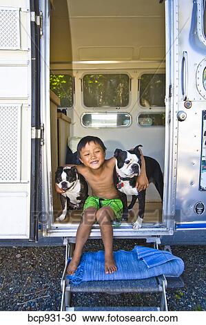 Boy sitting in door of camper with dogs View Large Photo Image Stock Image - Boy sitting in door of camper with dogs. Fotosearch