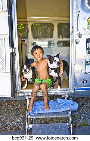 Boy sitting in door of camper with dogs View Large Photo Image Stock Photo - Boy sitting in door of camper with dogs. Fotosearch