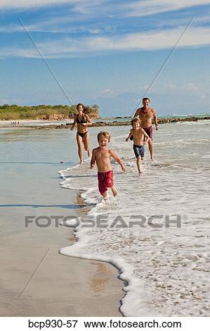 family running on beach in mexico View Large Photo Image Stock Photo - family running on beach in mexico. Fotosearch