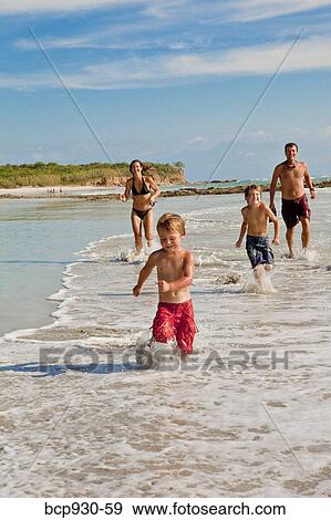 Stock Photo - family running on beach in mexico. Fotosearch