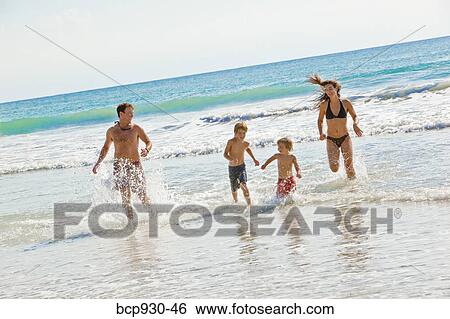 Stock Photograph - family running on beach in mexico. Fotosearch