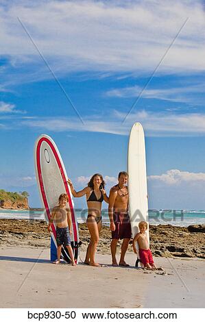 Stock Image - family with surboards on beach in mexico. Fotosearch