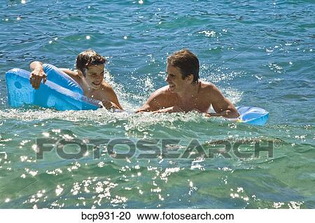 father and son on floaties in lake View Large Photo Image Stock Image - father and son on floaties in lake. Fotosearch