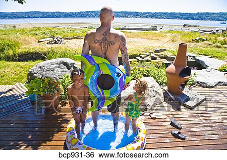 Stock Photograph - man with kids in wading pool near beach. Fotosearch