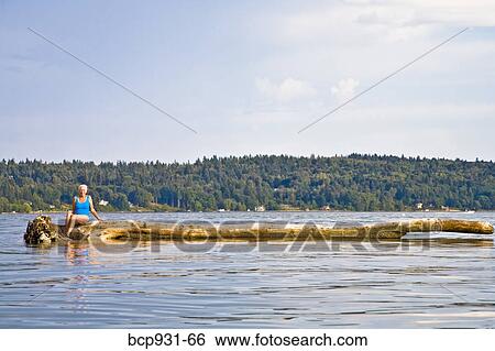 senior woman sitting on floating log View Large Photo Image Stock Photograph - senior woman sitting on floating log. Fotosearch