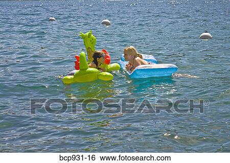 sisters chatting on floaties in lake View Large Photo Image Stock Photograph - sisters chatting on floaties in lake. Fotosearch