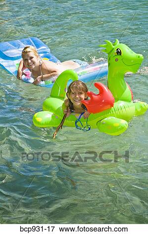 sisters on floaties in lake View Large Photo Image Stock Photo - sisters on floaties in lake. Fotosearch