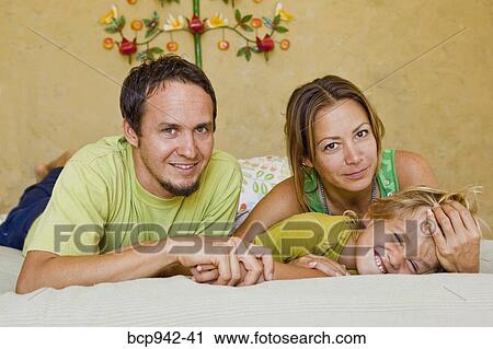 family cuddling on bed View Large Photo Image Stock Image - family cuddling on bed. Fotosearch
