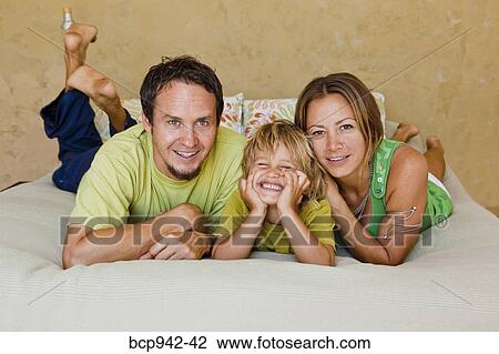 family cuddling on bed View Large Photo Image Stock Image - family cuddling on bed. Fotosearch