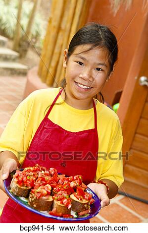 girl in apron holding tray of food View Large Photo Image Picture - girl in apron holding tray of food. Fotosearch