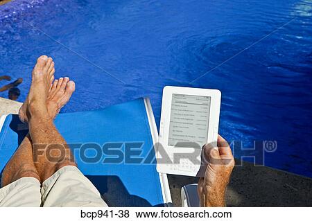man reading e-book on chaise outdoors View Large Photo Image Stock Photo - man reading e-book on chaise outdoors. Fotosearch