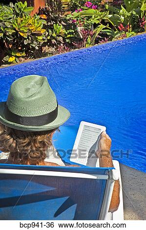 man reading e-book on chaise outdoors View Large Photo Image Stock Photograph - man reading e-book on chaise outdoors. Fotosearch