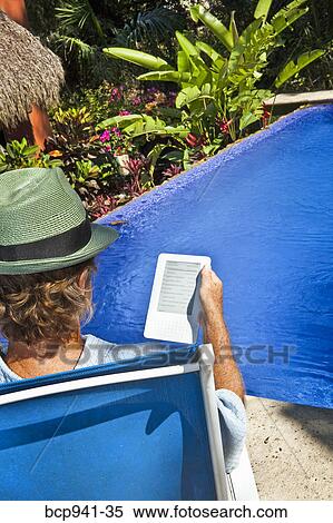 man reading e-book on chaise outdoors View Large Photo Image Stock Photography - man reading e-book on chaise outdoors. Fotosearch