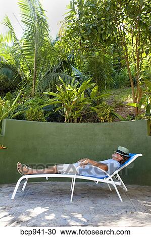 man resting on chaise outdoors View Large Photo Image Stock Image - man resting on chaise outdoors. Fotosearch