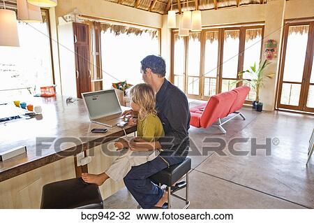 man working on laptop with child on lap View Large Photo Image Stock Image - man working on laptop with child on lap. Fotosearch