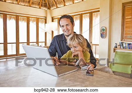 man working on laptop with child on lap View Large Photo Image Stock Photo - man working on laptop with child on lap. Fotosearch