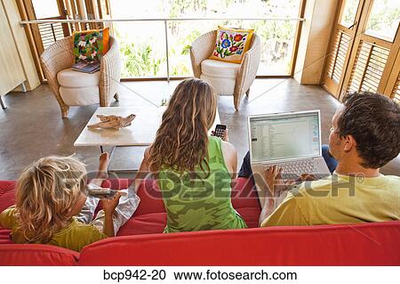 parents using laptop with child on sofa View Large Photo Image Stock Image - parents using laptop with child on sofa. Fotosearch