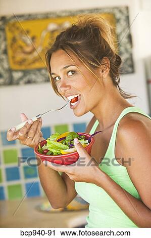 Stock Image - woman eating healthy food. Fotosearch