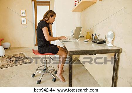 Picture - woman on laptop in home office. Fotosearch