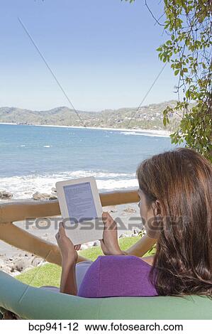 woman reading e-book on balcony View Large Photo Image Stock Image - woman reading e-book on balcony. Fotosearch