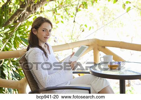 woman reading e-book on balcony View Large Photo Image Stock Image - woman reading e-book on balcony. Fotosearch