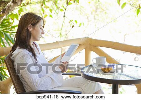 woman reading e-book on balcony View Large Photo Image Stock Photo - woman reading e-book on balcony. Fotosearch